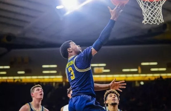 Jon Teske (15), Zavier Simpson (3), and Isaiah Livers (4)