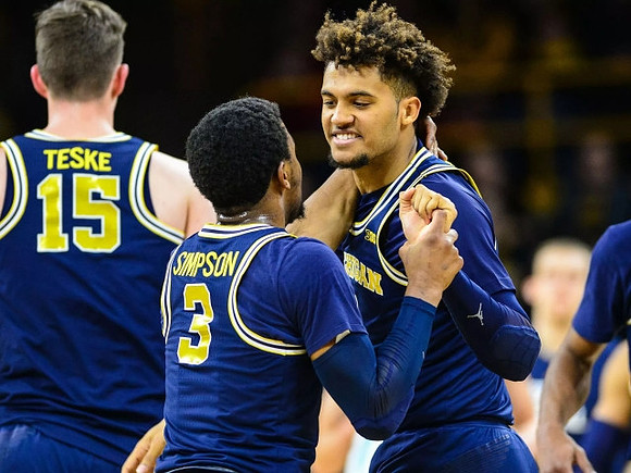 Jon Teske (15), Zavier Simpson (3), and Isaiah Livers (4)