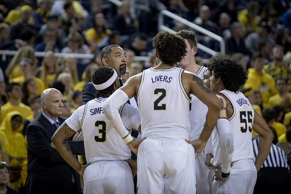 Phil Martelli, Zavier Simpson (3), Juwan Howard, Isaiah Livers (2), Jon Teske (15), and Eli Brooks (55)