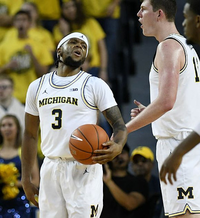 Zavier Simpson (3) and Jon Teske (15)