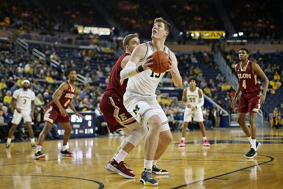Zavier Simpson (3), Jon Teske (15), and Eli Brooks (55)