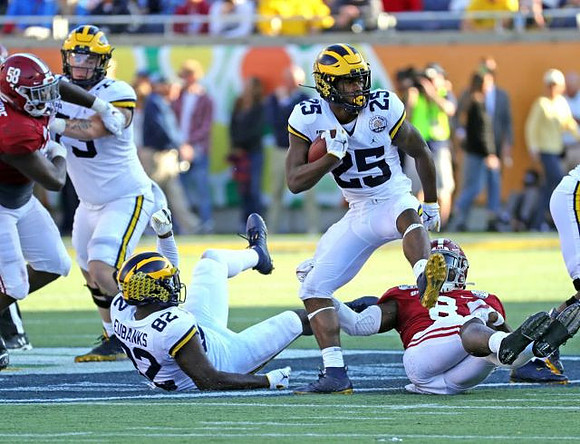 Jalen Mayfield (73), Nick Eubanks (82), and Hassan Haskins (25)