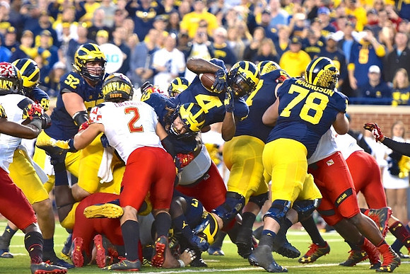 Mason Cole (52), Henry Poggi (19), De'Veon Smith (4), and Erik Magnuson (78)