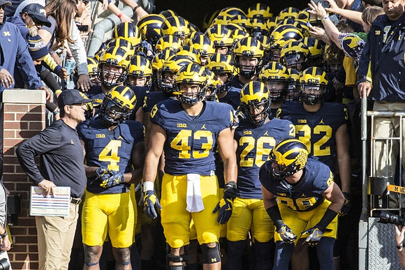 Jim Harbaugh, De'Veon Smith (4), Chris Wormley (43), Jourdan Lewis (26), Jake Butt (88), and Michigan Team