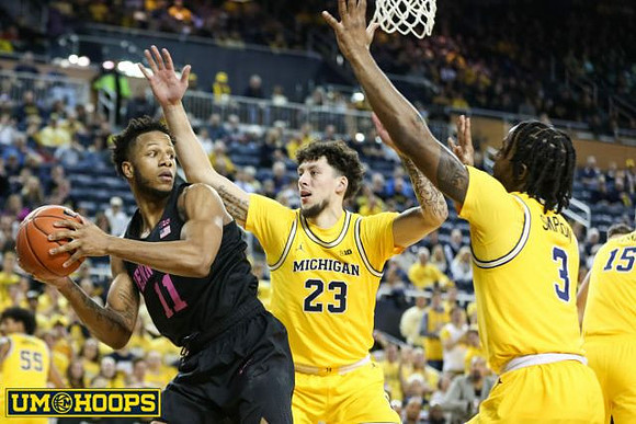 Brandon Johns Jr. (23), Zavier Simpson (3), and Jon Teske (15)