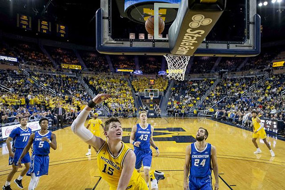 Zavier Simpson (3), Jon Teske (15), and Isaiah Livers (2)