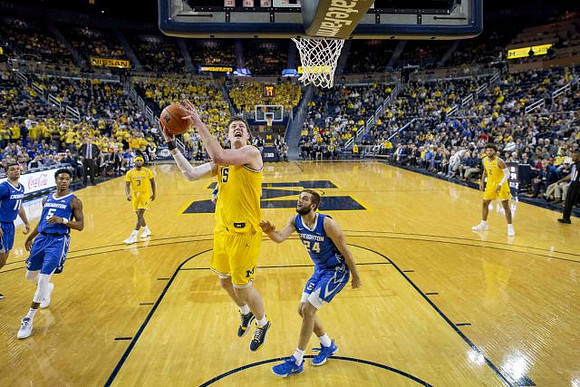 Zavier Simpson (3), Jon Teske (15), and Isaiah Livers (2)