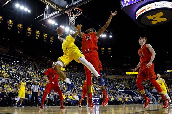 Zak Irvin (21), Derrick Walton Jr. (10), and Mark Donnal (34)