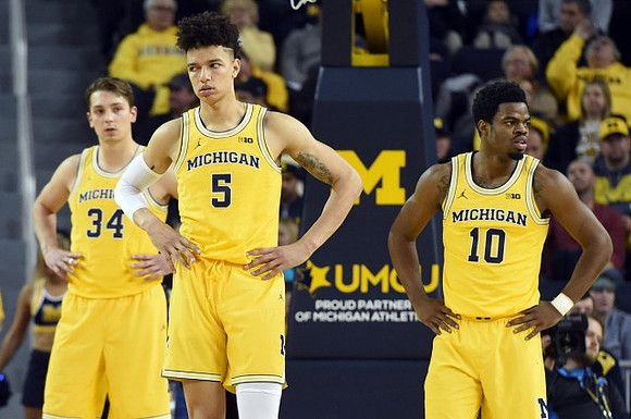 Mark Donnal (34), D.J. Wilson (5), and Derrick Walton Jr. (10)