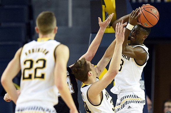 Duncan Robinson (22), Mark Donnal (34), and Caris LeVert (23)