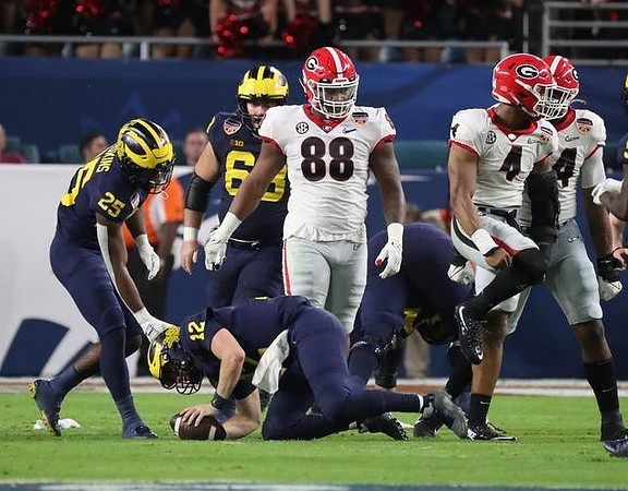 Hassan Haskins (25), Cade McNamara (12), and Andrew Vastardis (68)