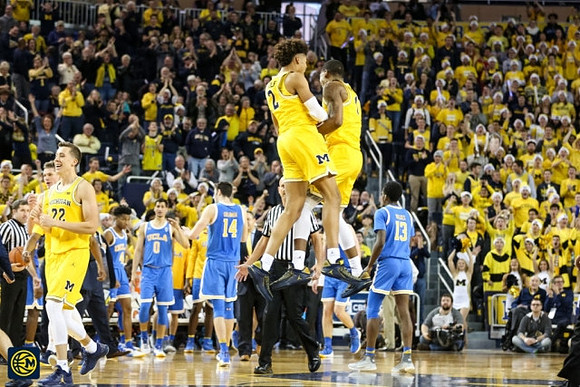 Duncan Robinson (22), Jordan Poole (2), and Zavier Simpson (3)