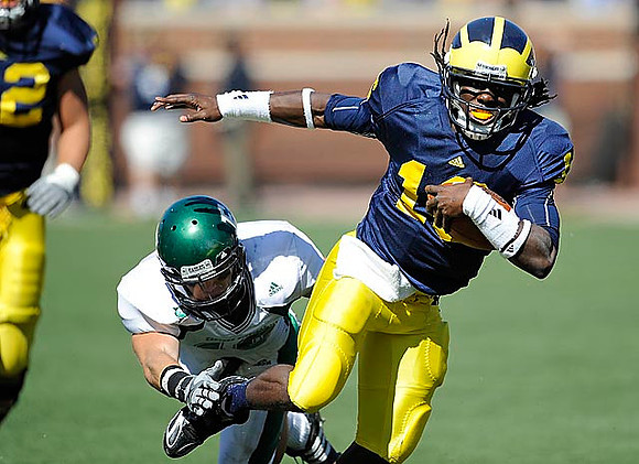Mark Huyge (72) and Denard Robinson (16)