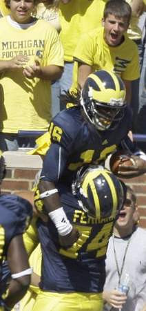 John Ferrara (74) and Denard Robinson (16)