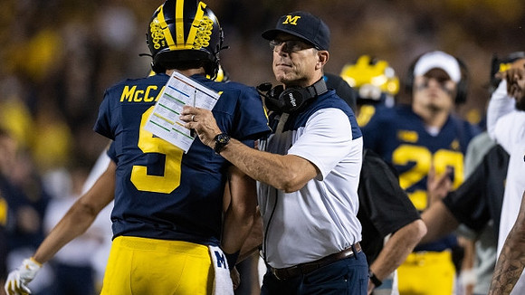 J.J. McCarthy (9) and Jim Harbaugh