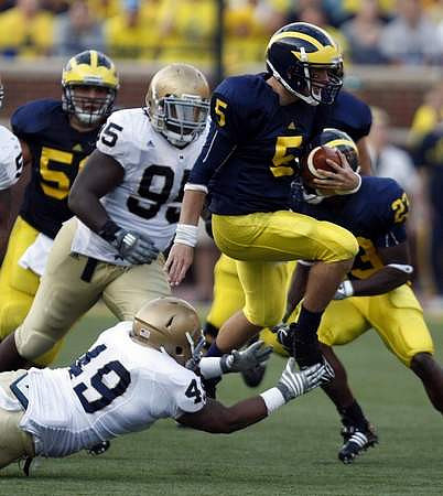 David Molk (50), Tate Forcier (5), and Carlos Brown (23)