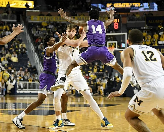 Hunter Dickinson (1) and DeVante' Jones (12)