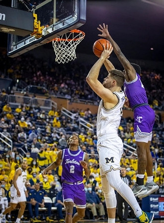 Hunter Dickinson (1) and DeVante' Jones (12)