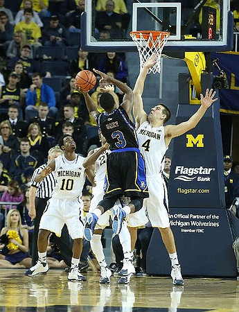 Derrick Walton Jr. (10), Zak Irvin (21), and Mitch McGary (4)