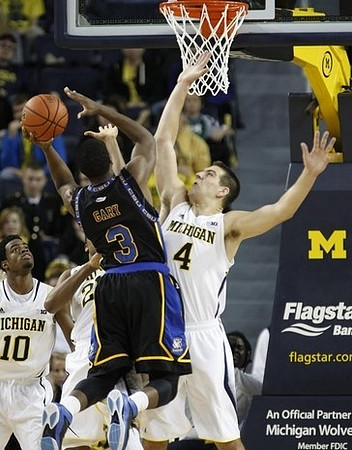 Derrick Walton Jr. (10), Zak Irvin (21), and Mitch McGary (4)