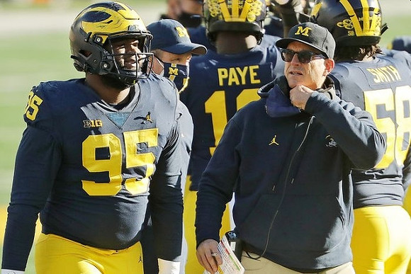 Donovan Jeter (95), Kwity Paye (19), Jim Harbaugh, and Mazi Smith (58)