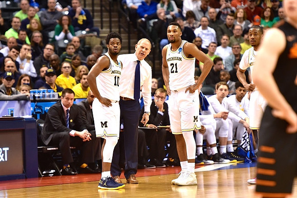 Derrick Walton Jr. (10), John Beilein, Zak Irvin (21), and Muhammad-Ali Abdur-Rahkman (12)