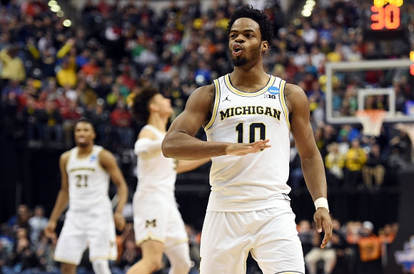 Zak Irvin (21), D.J. Wilson (5), and Derrick Walton Jr. (10)