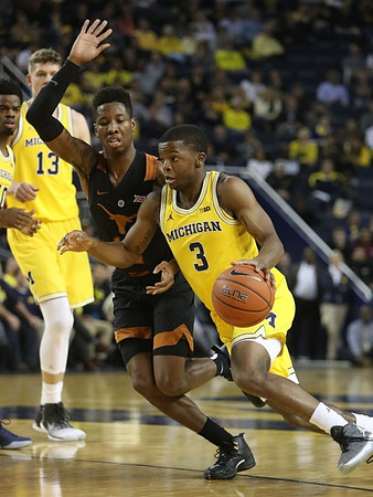 Derrick Walton Jr. (10), Moritz Wagner (13), and Xavier Simpson (3)