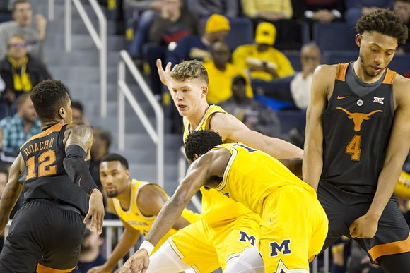 Zak Irvin (21), Moritz Wagner (13), and Derrick Walton Jr. (10)