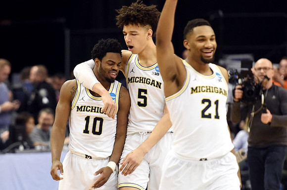 Derrick Walton Jr. (10), D.J. Wilson (5), and Zak Irvin (21)