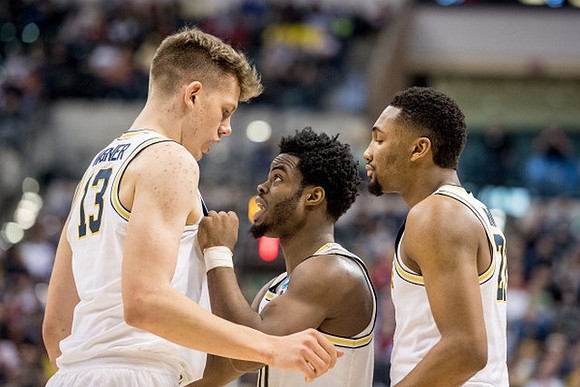 Moritz Wagner (13), Derrick Walton Jr. (10), and Zak Irvin (21)