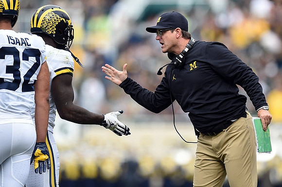 Ty Isaac (32) and Jim Harbaugh