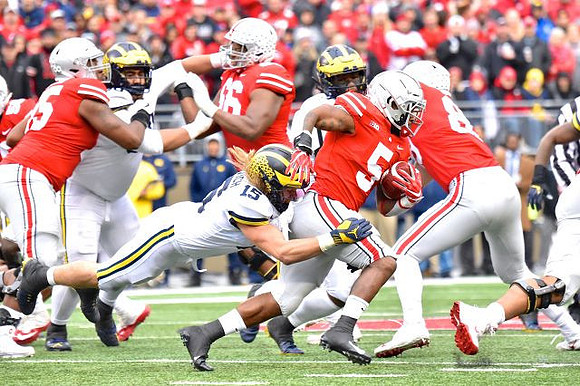 Bryan Mone (90) and Chase Winovich (15)