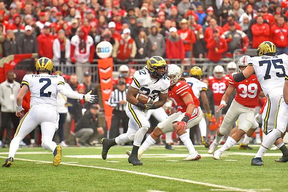 Shea Patterson (2), Karan Higdon (22), and Jon Runyan Jr. (75)