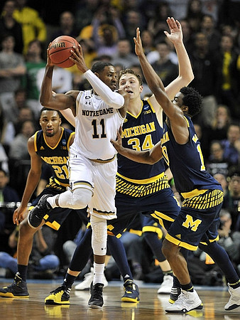Zak Irvin (21), Mark Donnal (34), and Derrick Walton Jr. (10)