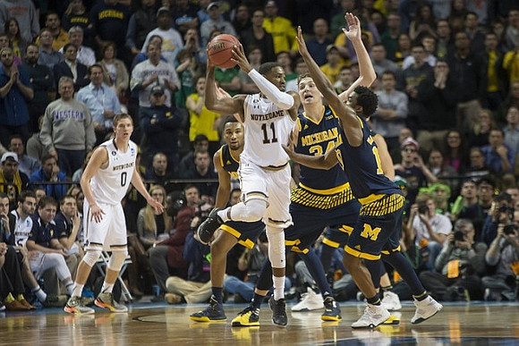Zak Irvin (21), Mark Donnal (34), and Derrick Walton Jr. (10)