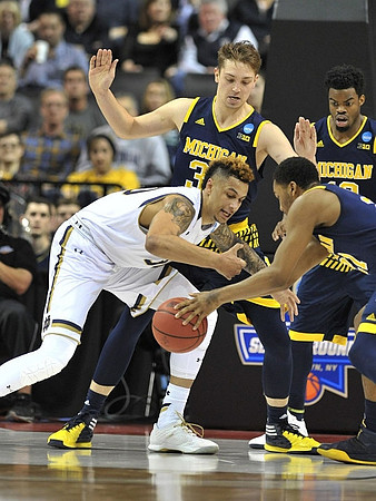 Mark Donnal (34), Zak Irvin (21), and Derrick Walton Jr. (10)