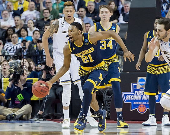 Zak Irvin (21), Mark Donnal (34), and Derrick Walton Jr. (10)