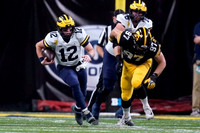 Cade McNamara (12) and Ryan Hayes (76)
