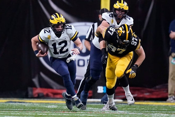 Cade McNamara (12) and Ryan Hayes (76)