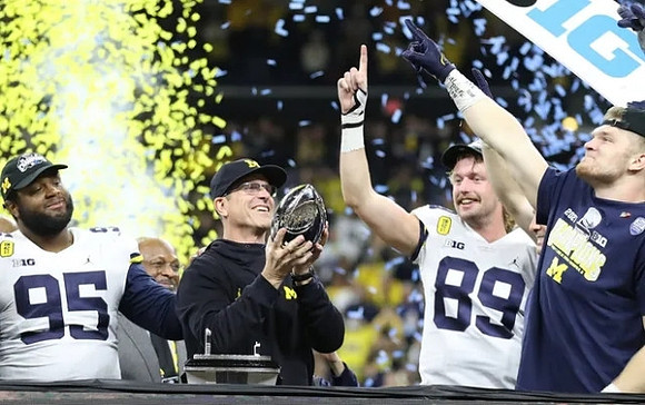 Donovan Jeter (95), Jim Harbaugh, Carter Selzer (89), Aidan Hutchinson (97), and Big Ten Conference Championship Trophy