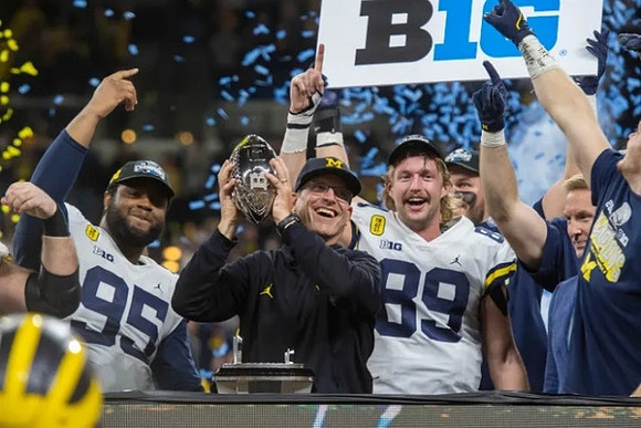 Donovan Jeter (95), Jim Harbaugh, Carter Selzer (89), and Big Ten Conference Championship Trophy