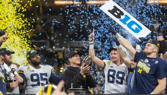 Andrew Vastardis (68), Donovan Jeter (95), Jim Harbaugh, Carter Selzer (89), Aidan Hutchinson (97), and Big Ten Conference Championship Trophy