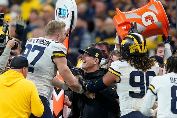 Aidan Hutchinson (97), Jim Harbaugh, and Mike Morris (90)