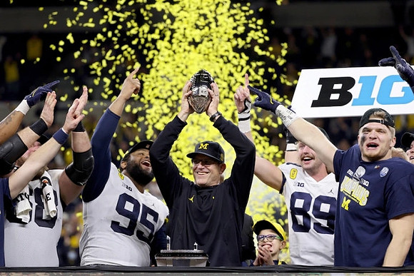 Andrew Vastardis (68), Donovan Jeter (95), Jim Harbaugh, Carter Selzer (89), Aidan Hutchinson (97), and Big Ten Conference Championship Trophy