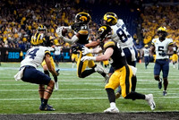 Joel Honigford (84), Erick All (83), Mike Sainristil (5), and Hassan Haskins (25)