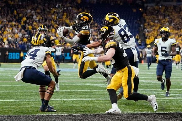 Joel Honigford (84), Erick All (83), Mike Sainristil (5), and Hassan Haskins (25)