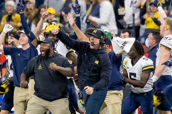 Jim Harbaugh, Mike Sainristil (5), and Aidan Hutchinson (97)