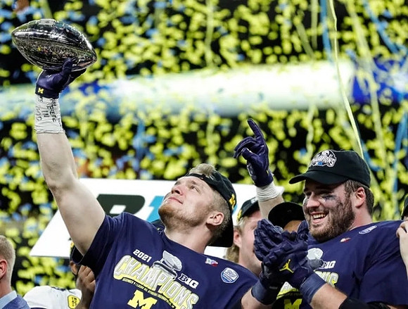 Aidan Hutchinson (97) and Big Ten Conference Championship Trophy