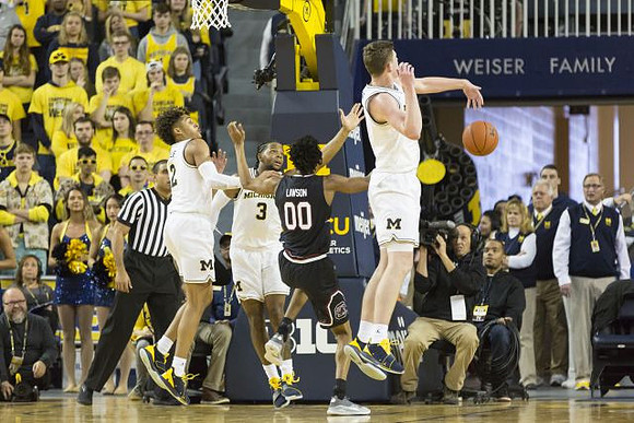 Jordan Poole (2), Zavier Simpson (3), and Jon Teske (15)